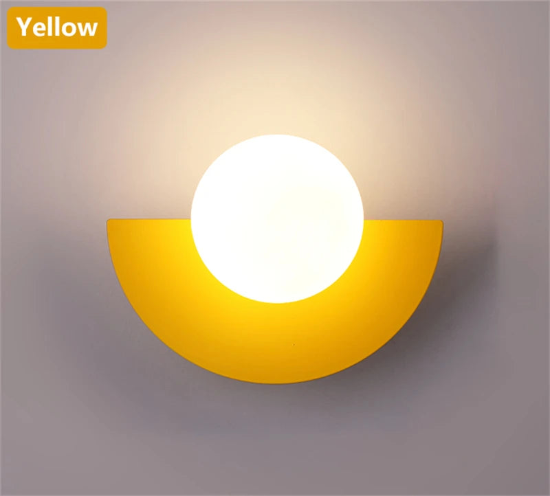 Yellow wall sconce with a white light bulb on a gray background
