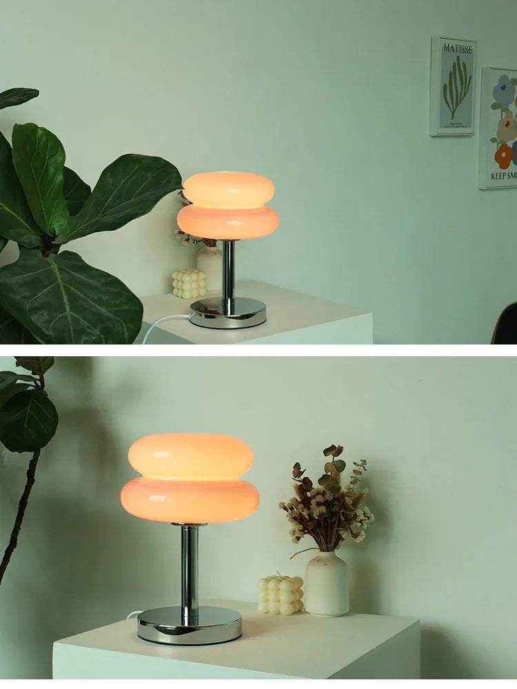 Modern table lamp with a unique design on a white surface, surrounded by decorative elements.