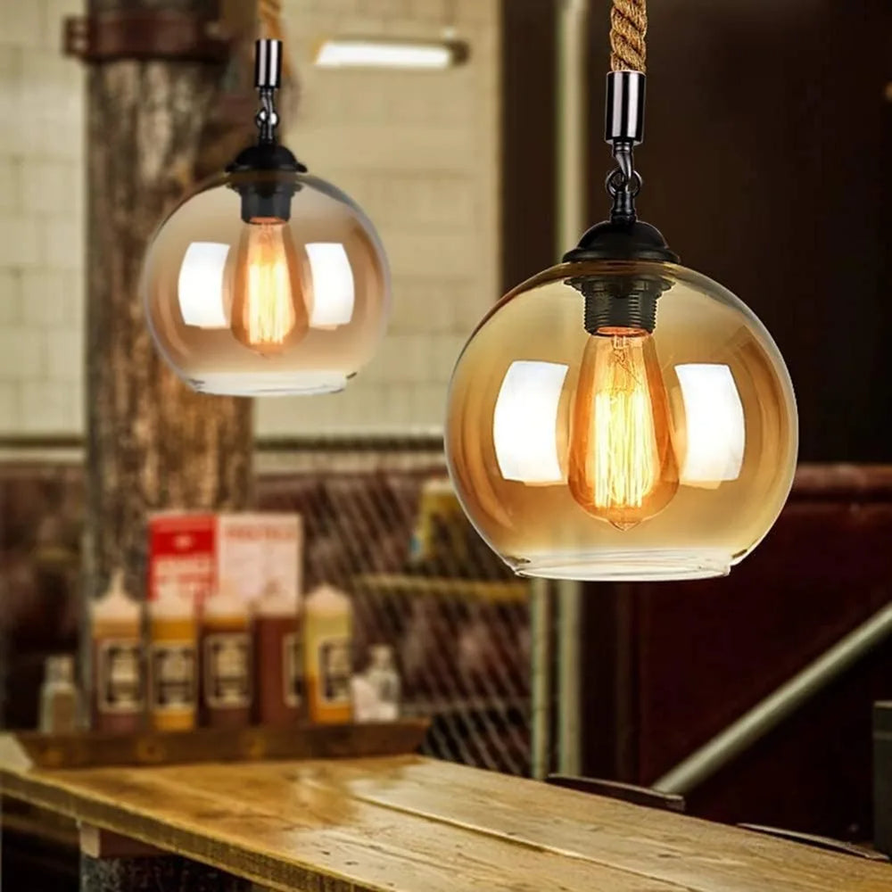 Two hanging pendant lights with glass shades and exposed bulbs in a rustic setting.