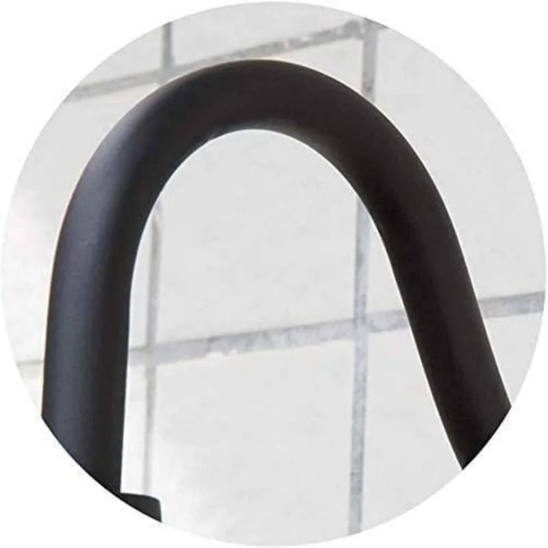 Close-up of a matte black metal U-shaped bar or handle, shown inside a circular frame against a light gray tiled background.