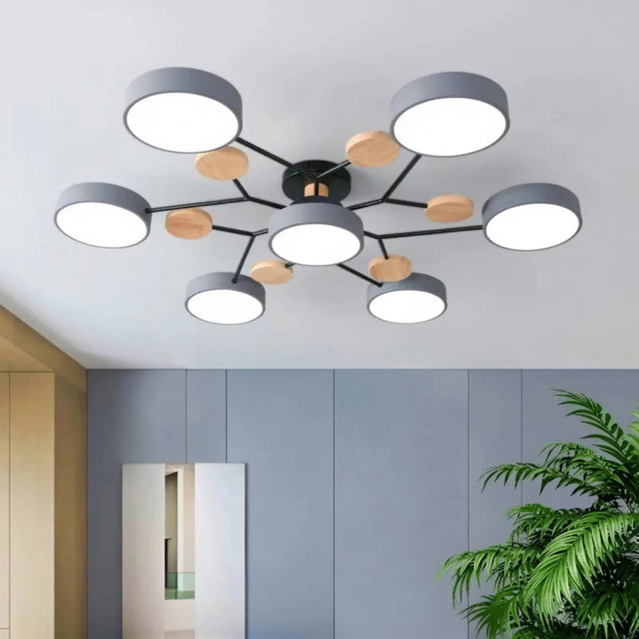 Modern ceiling light fixture with wooden accents in a room with gray walls and a plant.