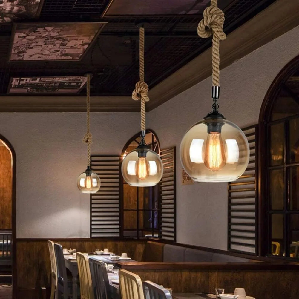 Pendant lights hanging in a restaurant setting with wooden tables and chairs.