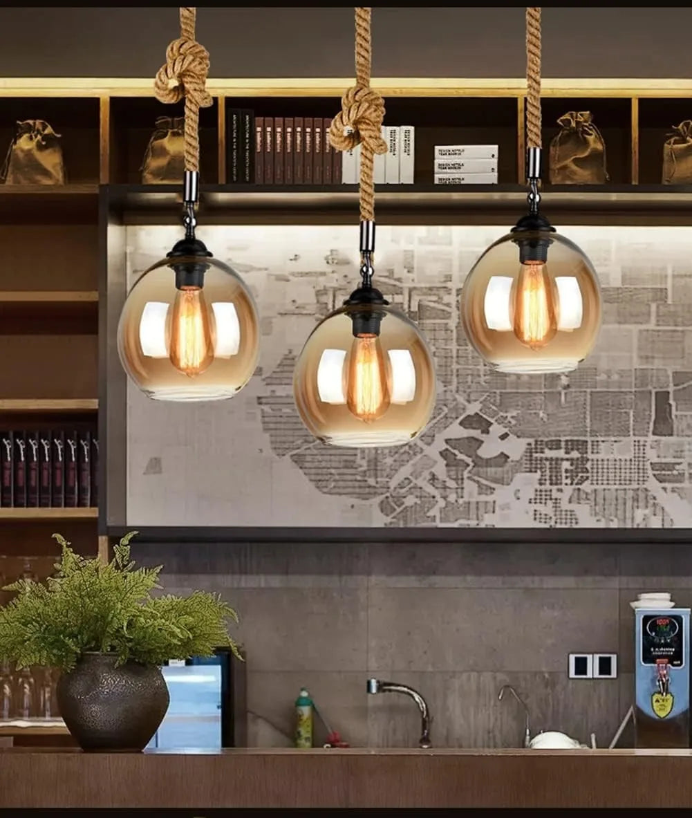 Three pendant lights hanging above a kitchen counter with a map on the wall.